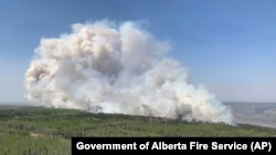 FILE - In this photo provided by the Government of Alberta Fire Service, a wildfire burns a section of forest in the Grande Prairie district of Alberta, Canada, May 6, 2023. Alberta faces another hot, dry weekend, with warnings of more intense wildfires.