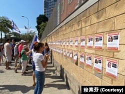 声援人质的参与者在处于特拉维夫市中心的国防部外墙上张贴附有人质照片的海报，形成一面受害者的海报墙，群众可逐一知悉受害者的脸孔、姓名和年龄，停留观看的民众心情沉重，仿佛是纪念碑。(美国之音 赖素芬)