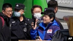 Chinese security personnel gather to remove Chinese journalists from the scene of an explosion in Sanhe city in northern China's Hebei province, March 13, 2024.
