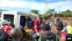 Paramedics carry a woman injured during flooding, in Kamuchiri village, Mai Mahiu, Nakuru County, Kenya, April 29, 2024.