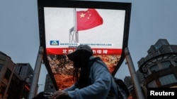 北京街头巨幅电视屏幕播放中国军队东部战区绕台军演的新闻。 (2024年5月23日)
