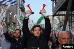 A supporter of PASOK Socialist party sounds two horns during the speech of PASOK Socialist party leader Nikos Androulakis in a pre-election rally in Athens, Greece, May 17, 2023.