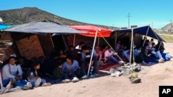 FILE - A group of people wait to be processed after crossing the border between Mexico and the United States as they seek asylum, April 17, 2024, near Jacumba, Calif.