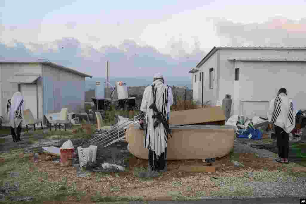 Jewish settlers pray in the Eviatar outpost in the Israeli-occupied West Bank during morning prayers calling for the legalization of the outpost and the return of the hostages held in the Gaza Strip by the Hamas militant group.