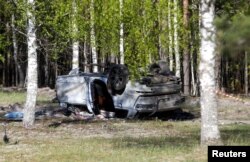 A view shows a white Audi Q7 car lying overturned on the ground next to a wood, after Russian nationalist writer Zakhar Prilepin was allegedly wounded in a bomb attack in a village in the Nizhny Novgorod region, Russia, May 6, 2023.