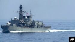 The British frigate HMS Lancaster sails as Iranian Revolutionary Guard vessels follow it in the Strait of Hormuz, May 19, 2023.