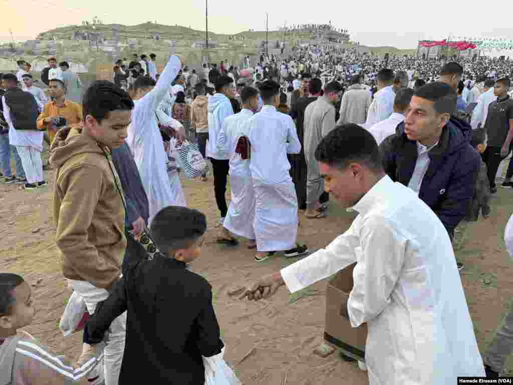 Brothers Mahmoud and Abdullah distribute dates among worshippers young and old. &ldquo;We try to spread happiness to people,&rdquo; says Mahmoud, &ldquo;and we wish that Palestinians will have time to celebrate Eid, too.&rdquo; Abusir, Egypt, April 10, 2024.