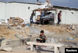 A boy looks on as Palestinians prepare to flee Rafah after Israeli forces launched a ground and air operation in the eastern part of the southern Gaza city, in Rafah, in the southern Gaza Strip, May 12, 2024.