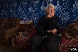 Olga Yefremova, 80, sits in Nova Kozacha, Ukraine, Feb. 14, 2023. She has not seen one of her daughters, two grandchildren and a great-granddaughter since the beginning of the war. She thinks they are in Russia. (Yan Boechat/VOA)