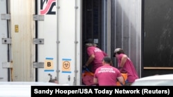 เจ้าหน้าที่ห้องเก็บศพเร่งน้ำร่างเหยื่อไฟป่าเกาะเมาวีเข้าไปเก็บในตู้เย็นคอนเทนเนอร์ ที่สำนักงานนิติวิทยาเขตเมาวีเคาน์ตี้ รัฐฮาวาย เมื่อวันที่ 15 ส.ค. 2023. 