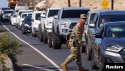 A member of Hawaii National Guard helps control traffic leaving Lahaina on the island of Maui in the U.S. state of Hawaii, Aug. 11, 2023.