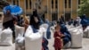 FILE - Afghan women receive food rations distributed by a humanitarian aid group, in Kabul, Afghanistan, May 28, 2023.
