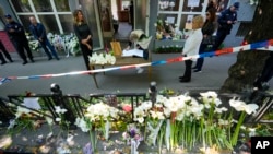 A girl signs a book of condolences in front of the Vladimir Ribnikar school, two days after a 13-year-old boy used his father's guns to kill eight fellow students and a guard, in Belgrade, Serbia, May 5, 2023.