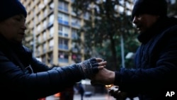 A vendor hands a customer a cup of coffee, in Santiago, Chile, May 17, 2024.