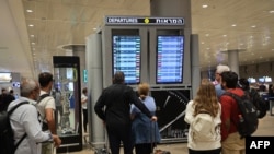 Passengers look at a departure board at Ben Gurion International Airport near Tel Aviv, Israel, as flights are canceled because of the Hamas attacks, Oct. 7, 2023.