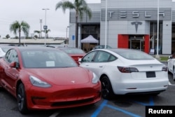 FILE - Tesla Model 3 vehicles are shown for sale at a Tesla facility in Long Beach, California, May 22, 2023.