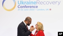 British Foreign Secretary James Cleverly, left, welcomes German Minister for Economic Cooperation and Development Svenja Schulze at the Ukraine Recovery Conference, in east London, June 21, 2023. 
