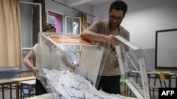 Election officials empty a ballot box to count the votes at a polling station during general elections in Thessaloniki, on June 25, 2023. 