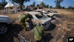 Israeli soldiers inspect the site of a music festival near the border with the Gaza Strip in southern Israel, on October 13, 2023, where at least 260 festival-goers were killed during the attack by Hamas gunmen on October 7. (AP Photo/Ariel Schalit/AP)