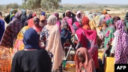 FILE - Refugees fleeing the conflict in Sudan, including violence in its western Darfur region, queue with jerrycans to collect drinking water from a distribution point at the Ourang refugee camp in Adre, Chad, on Dec. 7, 2023.