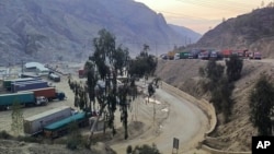 FILE - Trucks loaded with goods are seen parked at border crossing point Torkham in Afghanistan's eastern Nangarhar province, on the country's border with Pakistan, Feb. 21, 2023.