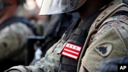 FILE - A solider from the District of Columbia National Guard watches as demonstrators gather to protest the death of George Floyd, June 3, 2020, near the White House in Washington. 