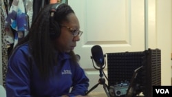 Tia Mitchell, the Washington correspondent for the Atlanta Journal Constitution, records a radio show on March 6, 2024, from her closet, where she says the audio quality is better. (Cristina Caicedo-Smit/VOA)