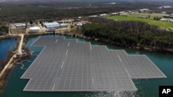 An array of solar panels float on top of a water storage pond in Sayreville, N.J., Monday, April 10, 2023. (AP Photo/Seth Wenig)