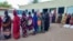 Internally displaced women wait in a queue to collect aid from a group at a camp in Gadaref on May 12, 2024, while clashes reignited between the Sudanese army and rival paramilitaries in the key Darfur town of El Fasher.
