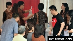 Warga etnis Tionghoa memberikan suara mereka di TPS pada putaran final Pilkada Jakarta pada 19 April 2017. (Foto: AFP/Bay Ismoyo)