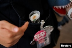 Rickshaw puller Nana Kamiyama, 21, points to her food on-the-go, at the Asakusa district in Tokyo, Japan, July 11, 2023.
