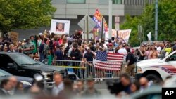 FILE - People watch after former President Donald Trump arrived at the E. Barrett Prettyman U.S. Federal Courthouse, Aug. 3, 2023, in Washington, to face a judge on federal conspiracy charges alleging Trump conspired to subvert the 2020 election. 