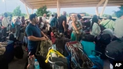 French and other nationals gather at the international Airport to be airlifted to France on a French military aircraft, in Niamey, Niger, Aug. 2, 2023.