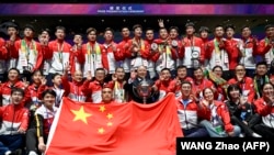 Para pemain bulu tangkis putra China berpose dengan trofi setelah mengalahkan Indonesia dalam final turnamen bulu tangkis Piala Thomas dan Uber di Chengdu, 5 Mei 2024. (Foto: WANG Zhao/AFP)