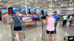 Shoppers push carts into a Costco warehouse, Aug. 4, 2023, in Thornton, Colorado.
