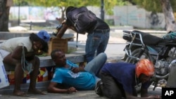 People take cover from gunfire during clashes between police and gangs in the Champs de Mars area next to the National Palace in Port-au-Prince, Haiti, April 8, 2024.