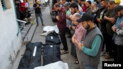 Mourners pray next to the bodies of Palestinians killed in Israeli strikes, amid the ongoing conflict between Israel and Hamas, during their funeral in Rafah, in the southern Gaza Strip, May 9, 2024.