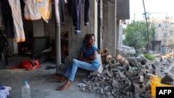 A displaced Palestinian girl sits in a damaged building used as a temporary shelter in al-Bureij refugee camp in the central Gaza Strip on June 12, 2024.
