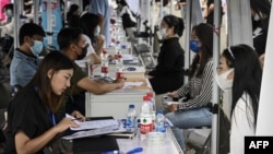 FILE - The photo taken on Aug. 26, 2022, shows young people attending a job fair in Beijing.