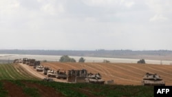 Israeli military vehicles roll near the border with the Gaza Strip on May 12, 2024.
