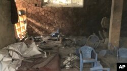 Afghan people, right, inspect the site of a bomb blast in Mazar-e-Sharif, the capital city of Balkh province, in northern Afghanistan, March 11, 2023. 