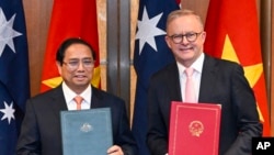 Australian Prime Minister Anthony Albanese and Vietnamese Prime Minister Pham Minh Chinh exchange documents during a signing ceremony at Parliament House in Canberra, Australia, March 7, 2024.