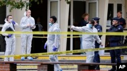 French police officers from the forensic service stand in front of the Gambetta high school in Arras after a man armed with a knife killed a teacher Oct. 13, 2023. 