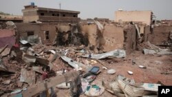 A man walks by a house hit in recent fighting in Khartoum, Sudan, April 25, 2023.