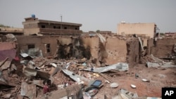 Seorang pria berjalan melewati bangunan rumah yang hancur di Khartoum, Sudan, pada 25 April 2023, akibat pertempuran yang terjadi di kota tersebut. (Foto: AP/Marwan Ali)