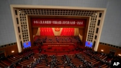 Para delegasi meninggalkan ruangan usai sesi pembukaan Kongres Nasional Rakyat China di Beijing, Minggu, 5 Maret 2023. (Foto: Ng Han Guan/AP Photo)