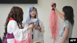 FILE - Manga-inspired cosplay fans attend a comics expo in Shanghai, China, July 11, 2013. China is circulating a draft version of a law to police clothing "hurtful" to the country's spirit, possibly including Japan-inspired costumes.