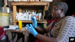 FILE - Traditional healer Florence Khoza talks to a patient before conducting a rapid HIV blood test in Bushbuckridge, South Africa, May 9, 2024.