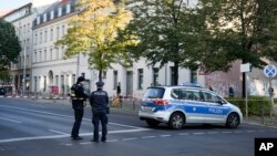 FILE - German police officers stand guard in front of the building complex of the Kahal Adass Jisroel community, which houses a synagogue, a kindergarten and a community center, in the center of Berlin, Germany, Oct. 18, 2023.