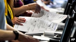 FILE - Election workers perform a recount of ballots from a Pennsylvania primary election at the Allegheny County Election Division warehouse in Pittsburgh, June 1, 2022.